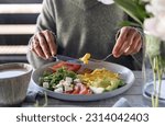 Female eating omelette on summer terrace. Healthy breakfast mood