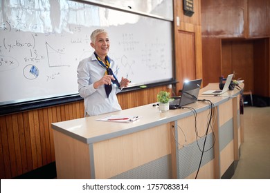 Female elderly professor giving a lecture from cathedra