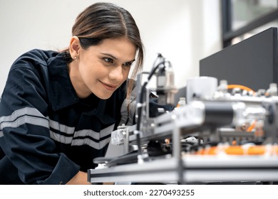 Female electronic engineer examining robotic equipment in engineering laboratory. Computer maintenance technician repairing automated robot hardware technology. Woman expertise in modern industry 4.0 - Powered by Shutterstock