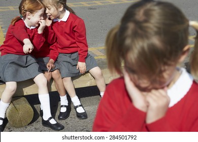 Female Elementary School Pupils Whispering In Playground