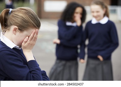 Female Elementary School Pupils Whispering In Playground