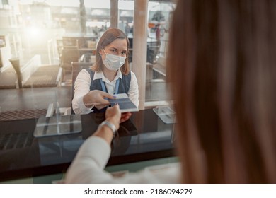 Female Employee In Mask Checking Passports And Biometric Data