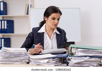 Weibliche Angestellte mit zu viel Arbeit im Büro 
