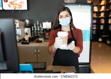 Female Employee Wearing Face Mask And Gloves While Serving Coffee In Restaurant