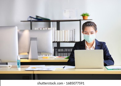 Female employee wearing medical facial mask working alone as of social distancing policy in the business office during new normal change after coronavirus or post covid-19 outbreak pandemic situation - Shutterstock ID 1685077591