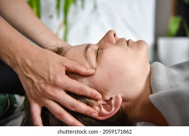 Female energy massage shiatsu relaxing and care treatment for body and mindfull health gentle woman arms holding head doing access bars and face young procedure