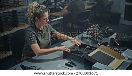 Female Engineer Assembling FPV Drone For Defense or Security Purposes. Focused Woman Meticulously Assembling Drone in Manufacturing Facility. Concept Women Role in Technology and Defense Production.