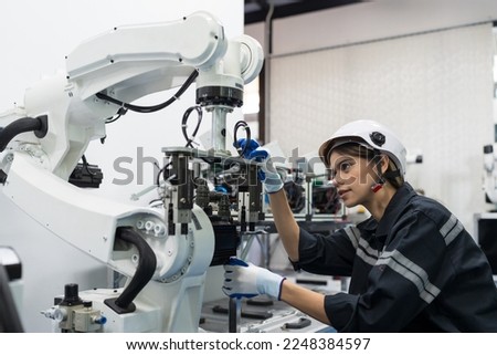 Female engineer control autonomous mobile robot or AMR in the manufacturing automation and robotics academy room. Woman engineer training or maintenance AI robot