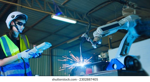 Female engineer controller operation robot arm testing system program welding with remote control. - Powered by Shutterstock