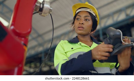 Female engineer controlling robot arm at factory. She checking the operation of robot arm. Technology, automation, innovation and engineering concept. - Powered by Shutterstock