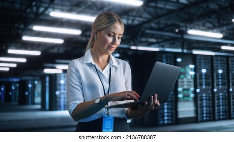 Female Engineer Holding Laptop Computer at Hands while Programs Something. She Works in Modern High-Tech Office. High-Speed Data Transfer and Smooth Server Operation, Analytics, Statistics Concept - Powered by Shutterstock