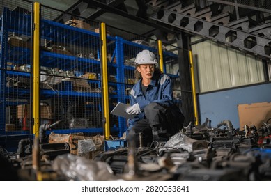 Female engineer holding tablet checking electric servo motor spare parts inventory in industrial warehouse, concept of heavy machinery automation repair and industrial equipment maintenance service.