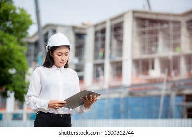 Female engineer inspecting construction work in hand holding clipboard