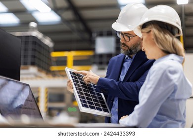 Female engineer and male director talking in modern industrial factory about solar panels installation, solar energy for company. Team management in manufacturing facility, green renewable energy for - Powered by Shutterstock