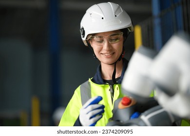An Female engineer in research development robotic factory checking prototype of automation robot arm