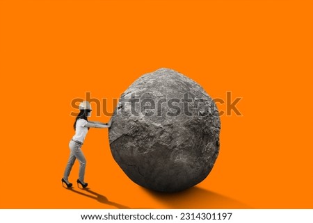 Female engineer with safety helmet pushing big rock