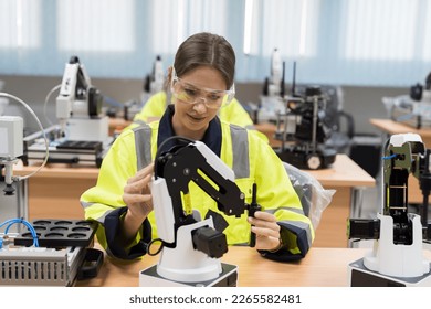 Female engineer training or maintenance AI Robot and Artificial Intelligence of Things service robot in the manufacturing automation and robotics classroom
