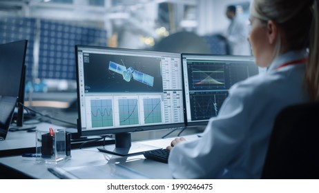 Female Engineer uses Computer to Analyse Satellite, Calculate Orbital Trajectory Tracking. Aerospace Agency International Space Mission: Scientists Working on Spacecraft Construction. Over Shoulder