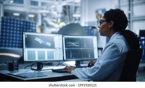 Female Engineer Uses Computer To Analyse Satellite, Calculate Orbital Trajectory Tracking. Aerospace Agency International Space Mission: Scientists Working On Spacecraft Construction. Over Shoulder