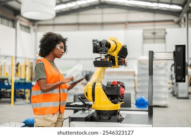 Female engineer uses a digital tablet to program and control a robotic arm inside a modern factory, showcasing the integration of technology and human expertise in industrial automation - Powered by Shutterstock