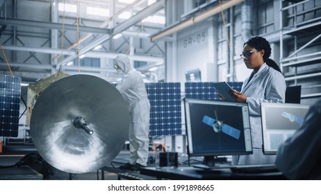 Female Engineer Uses Tablet Computer While Working On Satellite Construction. Aerospace Agency Manufacturing Facility: Scientists Build, Assemble Spacecraft For Space Exploration, Observation Mission