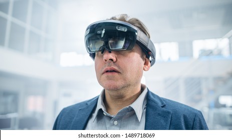 Female Engineer Using Augmented Reality Headset. and Moving Virtual Pieces in the Air. In Innovation High Tech Laboratory Facility with Futuristic Atmosphere.