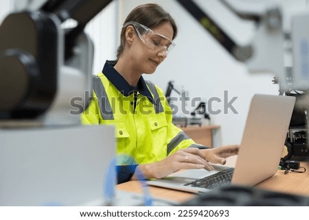 Female engineer using laptop computer for training Programmable logic controller. Woman programmer create programmable computer for control AI robot in the robotics laboratory room