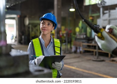 Female engineer in vest and helmet safety with clipboard checking and repairing machine at heavy metal factory.Preventive Maintenance concept - Shutterstock ID 2220193811