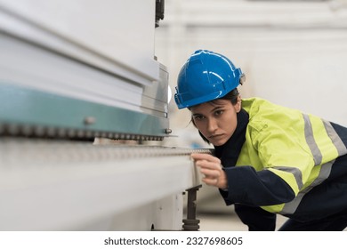 Female engineer worker checking conveyor belt machine at the industry factory. Female technician wear safety uniform working maintaining machine in the factory - Powered by Shutterstock