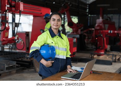 Female engineer worker working with laptop computer for maintenance robot arm system welding at production plant factory - Powered by Shutterstock