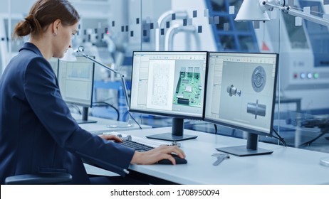 Female Engineer Working on a Personal Computer, Two Monitor Screens Show Chroma Key / Green Screen Display and CAD Software with 3D Model of Industrial Machinery Mechanism. Working Modern Factory