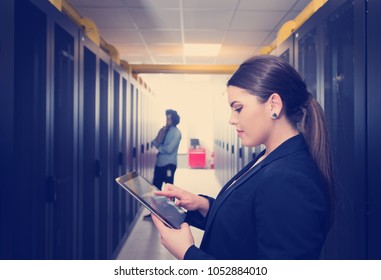 Female IT Engineer Working On A Tablet Computer In Server Room At Modern Data Center