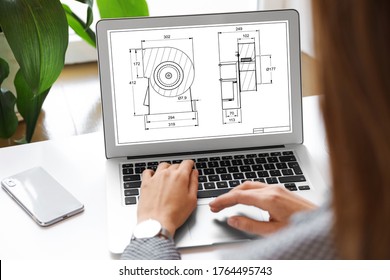 Female Engineer Working With Technical Drawing On Laptop Indoors, Closeup