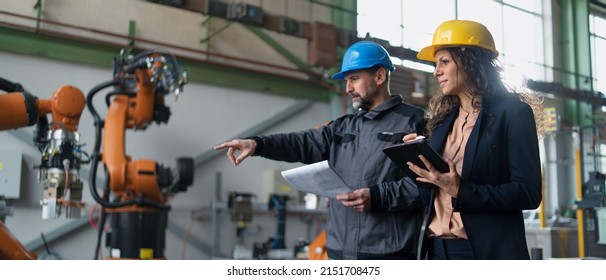 Female engineering manager and mechanic worker doing routine check up in industrial factory - Powered by Shutterstock