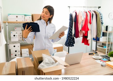 Female Entrepreneur Working On Her Business Start-up And Unpacking Boxes From Her Suppliers For The Online Clothing Shop