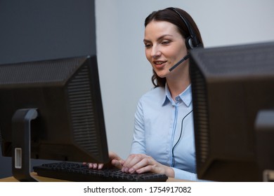 Female executive with headset using computer at desk in office - Shutterstock ID 1754917082