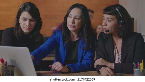 Female Executive Presenting Data To Staff In Front Of Computer Laptop. Female Employees Listening To Female Leader Explaining Information