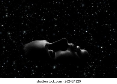 female face profile with closed eyes on stars sky background, monochrome