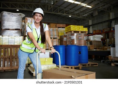 Female Factory Worker Pushing Cart With Corrugated Box In The Warehouse Storage