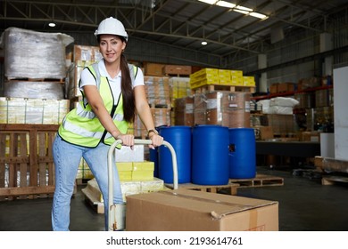 Female Factory Worker Pushing Cart With Corrugated Box In The Warehouse Storage