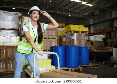 Female Factory Worker Pushing Cart With Corrugated Box In The Warehouse Storage