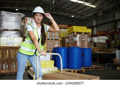 Female Factory Worker Pushing Cart With Corrugated Box In The Warehouse Storage