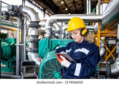 Female Factory Worker Working On Tablet Computer In Oil And Gas Refinery Plant.