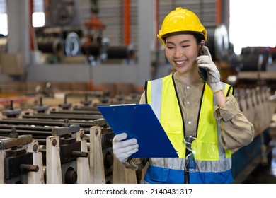 female factory workers or engineer talking on smartphone and looking information on clipboard in factory - Powered by Shutterstock