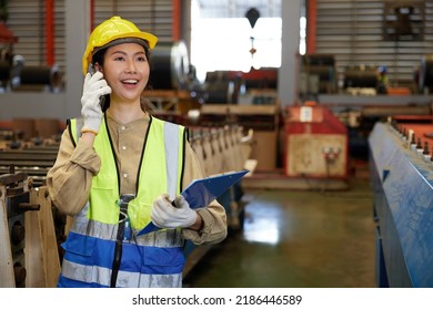 female factory workers or engineer talking on smartphone and looking information on clipboard in factory - Powered by Shutterstock