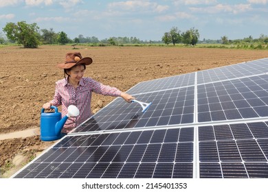 Female Farmer Cleaning Solar Panels In Farm