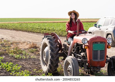 Female Farmer Driving A Tractor In Field