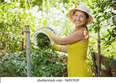 Female Farmer Making Compost In Garden