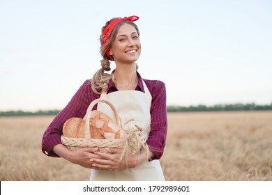 Female farmer standing wheat agricultural field, Woman baker holding wicker basket bread eco product Baking small business Caucasian person dressed red checkered shirt apron organic healthy food 
