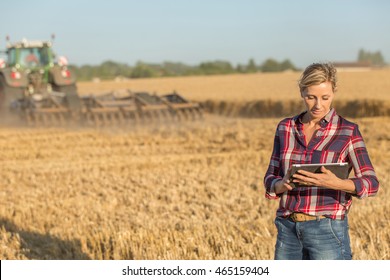 Female Farmer Standing In Wheat Field